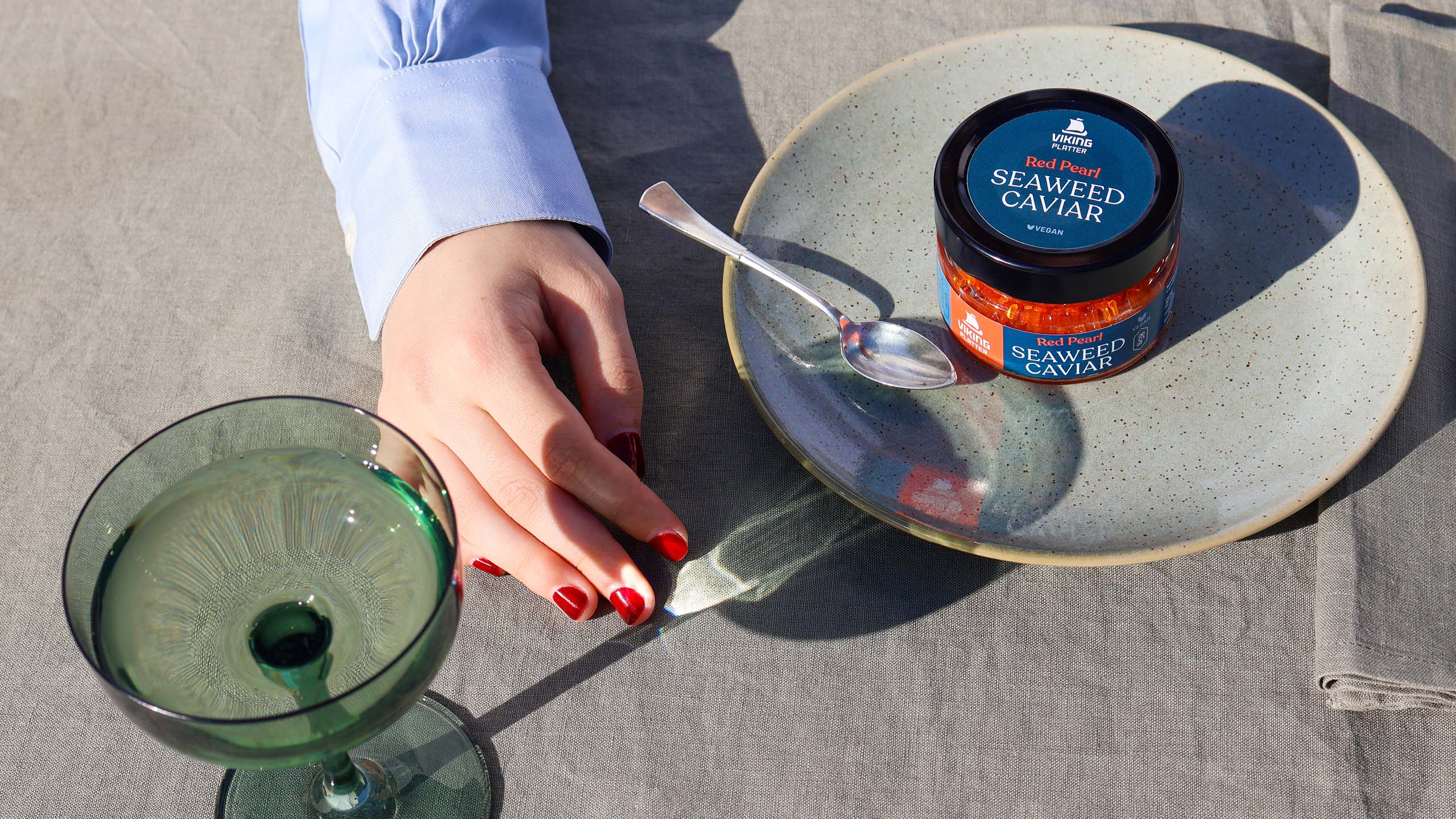 Young woman's hand next to packaging for Viking Imports Red Pearl Seaweed Caviar