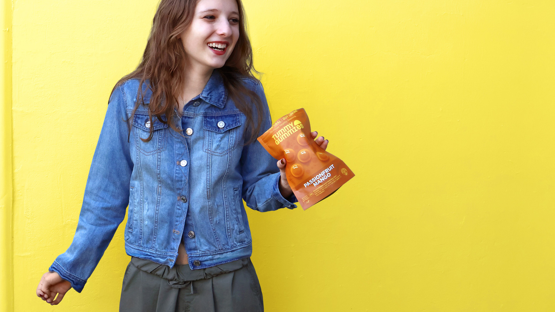 Girl holding package of Passionfruit Mango Tummy Gummies