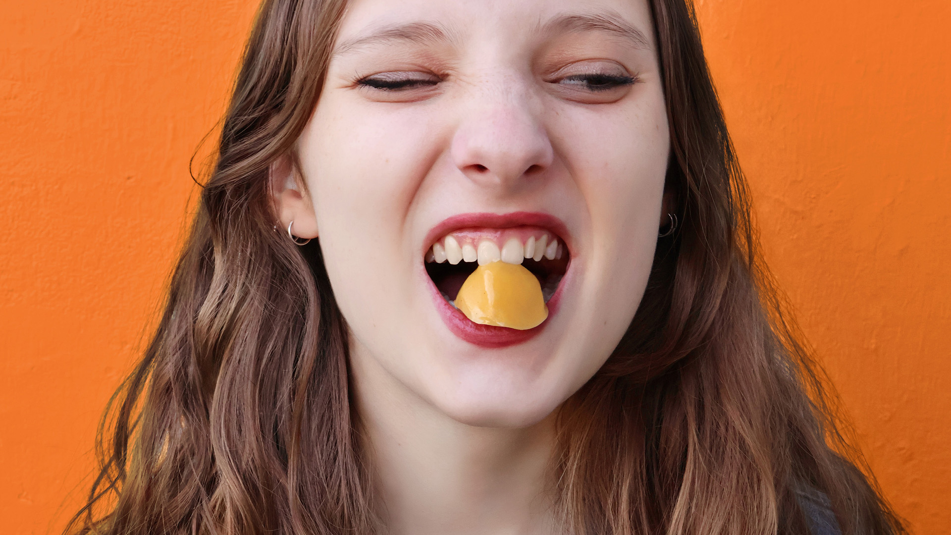 Girl eating a fruit gummy from Tummy Gummies